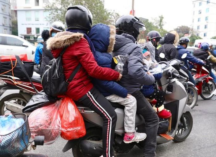Một gia đình cùng đồ đạc lỉnh kỉnh trên xe, rời Hà Nội về quê đón Tết.