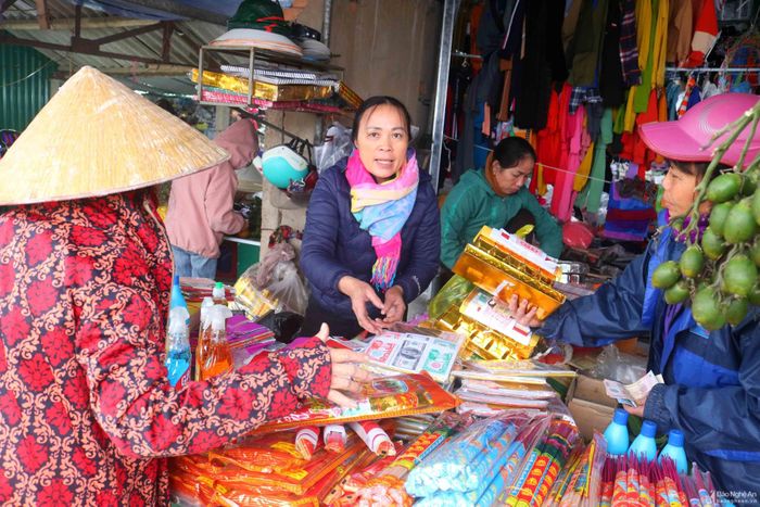 Hàng mã, hàng trầu cau, hàng hoa quả ở chợ Tết cũng mua bán tấp nập. Không ít người đi chợ Tết chỉ mua vàng mã đủ để cúng Tết theo truyền thống, nhằm tiết kiệm tiền bạc và giảm ô nhiễm môi trường. Ảnh: Đình Tuyên