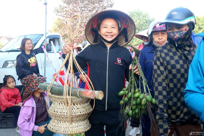 Trước khi đi chợ, các bà, các mẹ thường dự tính sẽ mua sắm Tết những thứ gì, có người còn ghi ra giấy để khỏi quên. Ai cũng muốn mua được những thứ mình cần, mình thích, phục vụ thiết thực cho việc ăn Tết của gia đình. Trong ảnh: Niềm vui của một bà cụ ở xã Thanh Đồng (Thanh Chương) đi chợ Tết mua sắm được đôi kiềng treo thức ăn vừa ý, buồng cau tươi cùng những ống giang để về gói bánh chưng. Ảnh: Huy Thư