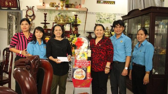 Bà Lê Thị Kim Thúy, Phó Chủ tịch LĐLĐ TP HCM (thứ 3 từ phải sang) tặng quà cho chủ nhà trọ Nguyễn Thị Tuyết Thương