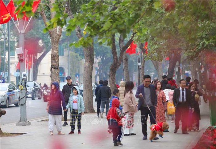 Người dân Thủ đô cùng du khách tới Hồ Gươm để tản bộ, ngắm cảnh, chụp ảnh lưu niệm, tận hưởng không khí rực rỡ, ấm áp của mùa Xuân đang về.