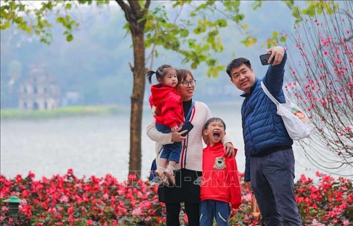 Một gia đình chụp ảnh ghi lại khoảnh khắc của mùa xuân bên Hồ Gươm.