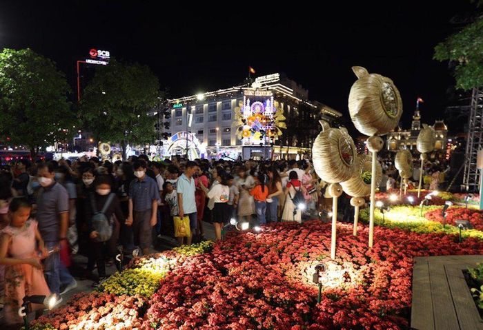 Tại TP Hồ Chí Minh, hàng nghìn người đổ về đường Nguyễn Huệ để đón chờ thời khắc chuyển giao năm mới. Ảnh: Tiểu Thúy