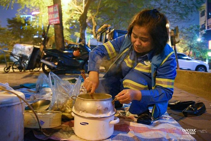 Tranh thủ giờ nghỉ giữa ca, anh chị em Tổ môi trường 5 mỗi người một tay, một chân bày biện mâm cơm ngay bên vỉa hè.