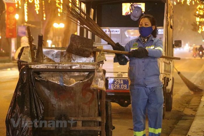  Các đội công nhân vệ sinh môi trường làm việc trong ngày cuối cùng của năm cũ. (Ảnh: Việt Anh/Vietnam+) 