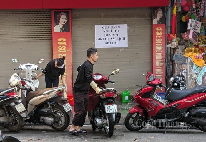 Đôi vợ chồng này vừa bán hàng phục vụ Tết vừa tranh thủ rửa nốt những chiếc xe máy