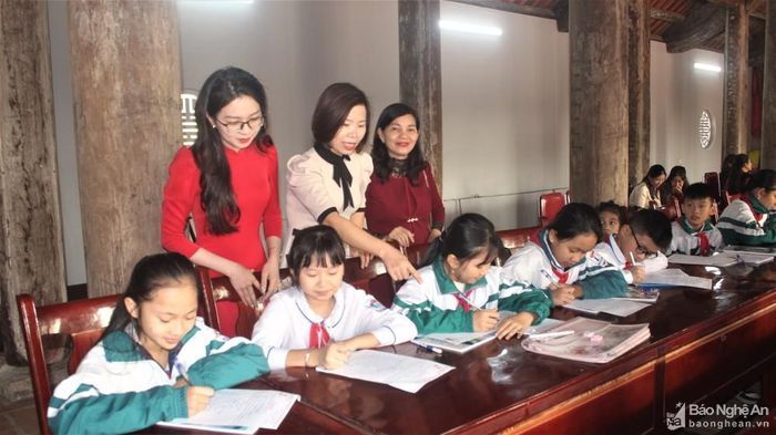 Các em học sinh sáng tác những bài thơ, đoạn văn nói về quê hương, con người làng Quỳnh Đôi. Ảnh: Việt Hùng