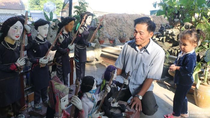 Lão nông Hồ Văn Thân và cháu nội bên dàn rối điện. Ảnh: Khánh Ly
