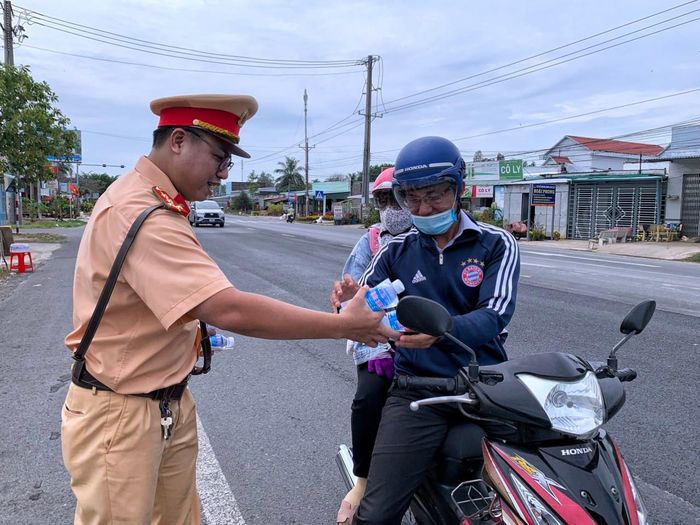 Lực lượng CSGT Công an tỉnh Bạc Liêu trao tận tay người dân chai nước suối để giải khát rồi tiếp tục hành trình. 