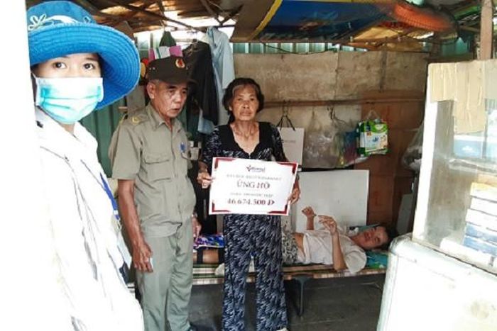 Đại diện phòng Công tác xã hội (ngoài cùng bên trái) tới thăm và trao số tiền bạn đọc VietNamNet ủng hộ cho anh Lâm Ngọc Điệp.