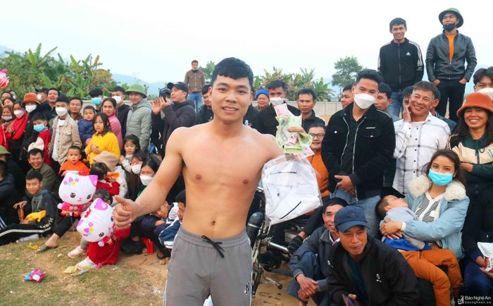Anh Hoàng Sơn (20 tuổi) ở xã Nam Nghĩa cho biết, anh vừa hoàn thành nghĩa vụ quân sự và rất hào hứng tham gia hội vật đầu Xuân ở quê hương. "Em rất may mắn khi thắng 3 đô vật liên tiếp trong trận đấu, được bà con cổ vũ tưng bừng" - anh Sơn chia sẻ. Ảnh: Huy Thư