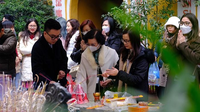  Phía ngoài sân, khu vực sắp lễ cũng khá đông đúc. Mọi người phải xếp hàng chờ đến lượt châm hương, chuẩn bị đồ lễ. 