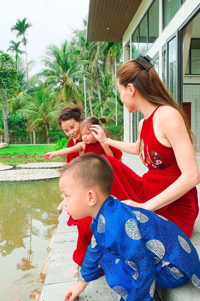 Cô cùng mẹ đẻ và các con cho cá ăn.