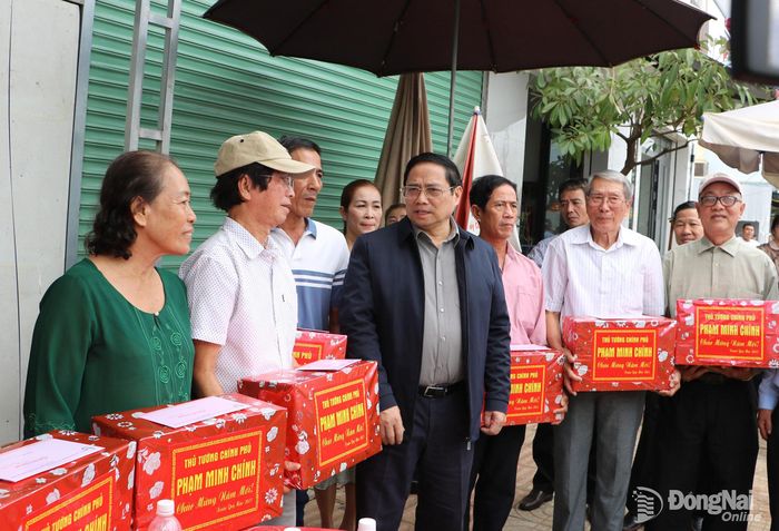 Thủ tướng Phạm Minh Chính tặng quà cho một số hộ dân đã chuyển đên sinh sống tại khu tái định cư Lộc An - Bình Sơn