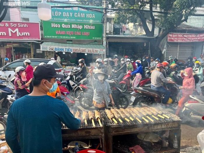 Cả tuyến đường dài gần 1km thơm phức mùi cá nướng. Nhiều chủ cửa hàng tất bật nướng cá để kịp bán cho khách mang về cúng.