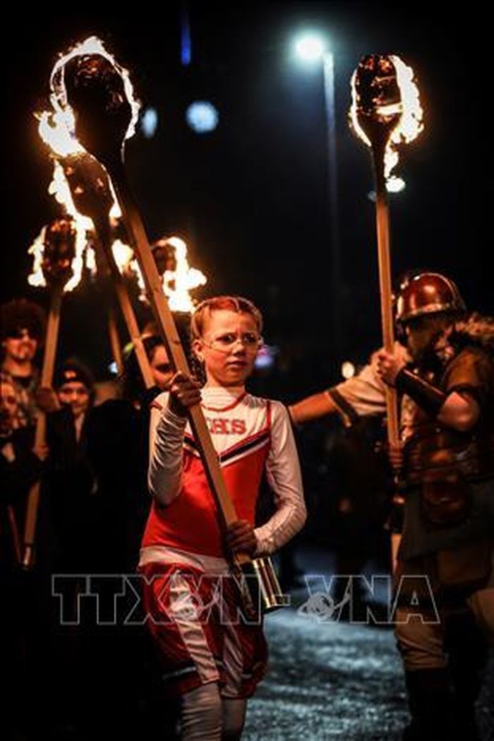 Bé gái tham gia rước đuốc tại lễ hội lửa Up Helly Aa ở Lerwick, thủ phủ đảo Shetland (Scotland), ngày 31/1/2023. Ảnh: AFP/TTXVN