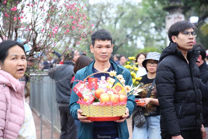 Sau khi dâng lễ, thành tâm cúng bái, nhiều du khách chọn ở lại trong khuôn viên khu di tích đền Trần và đợi chờ đến thời điểm khai ấn và phát ấn. Theo họ, việc đợi chờ trong khuôn viên đền Trần mới đảm bảo sự thành tâm với đức thánh Trần. Ảnh: TRỌNG TÀI.