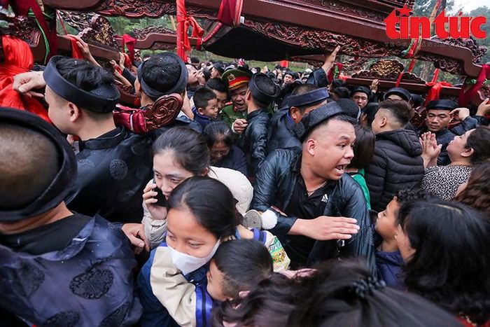 Việc quá đông người chen lấn khiến những người rước kiệu luôn phải giữ vững tay để kiệu không bị đổ.