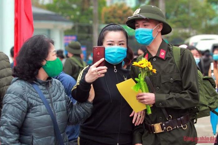 Những bó hoa, những chiếc ôm vội vàng được trao gửi như một lời động viên dành cho các tân binh lên đường nhập ngũ.