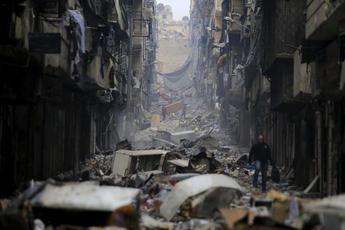  Người dân băng qua đống đổ nát trên khu phố Salaheddine từng do phiến quân nắm giữ ở phía đông Aleppo, ngày 20/1/2017. Ảnh: AP. 