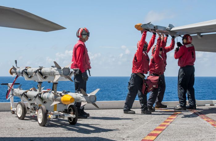  Lính Mỹ lắp tên lửa AIM-9X lên tiêm kích F/A-18F trên tàu sân bay USS Ronald Reagan. Ảnh: Hải quân Mỹ. 