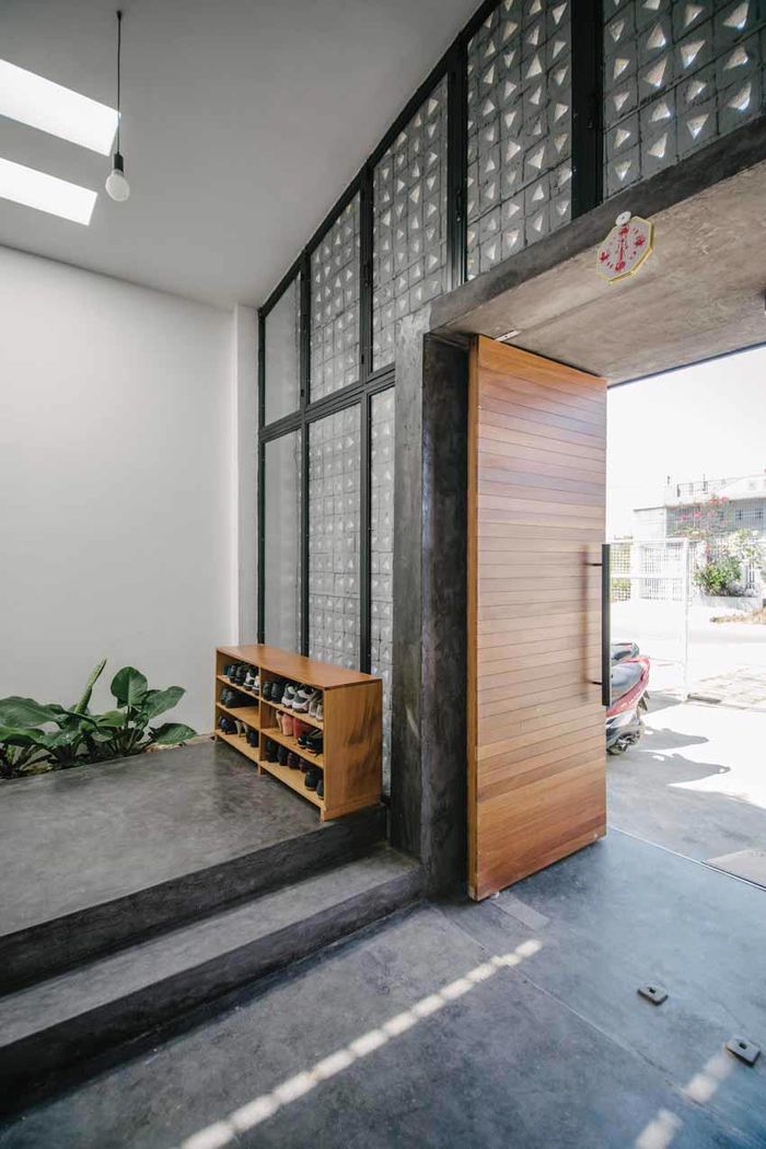 Chỗ để xe nhà nhỏ vùng ven bố trí cạnh lối vào, tủ giày và thấp hơn hai bậc để phân cấp không gian