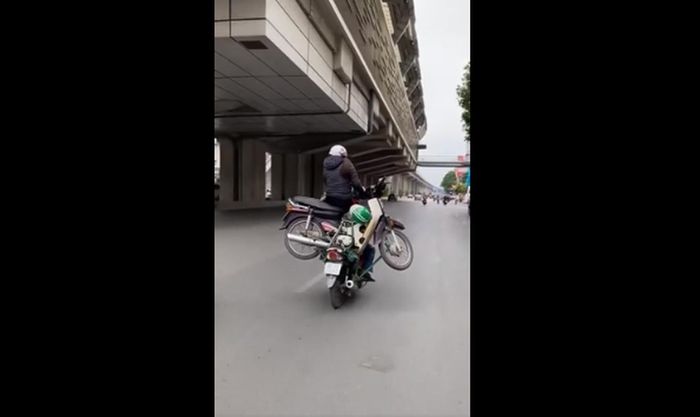 Người phụ nữ ngồi vắt vẻo trên xe không màng tới nguy cơ tai nạn có thể xảy đến trong tích tắc.