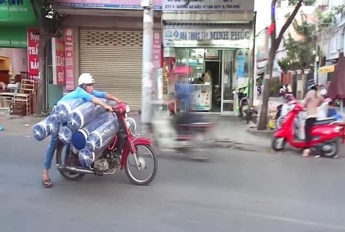 Tuy nhiên, thay vì chuyên chở những mặt hàng nhỏ gọn thì nhiều người tại Việt Nam lại sử dụng xe máy để chở hàng quá khổ, nhiều khi gây ảnh hưởng đến những người đi lại xung quanh. Ảnh: Cắt ra từ clip