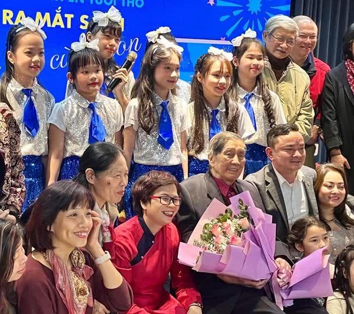 Nhạc sĩ Phạm Tuyên (cầm hoa) trong buổi ra mắt sách của con gái (bên phải ông)