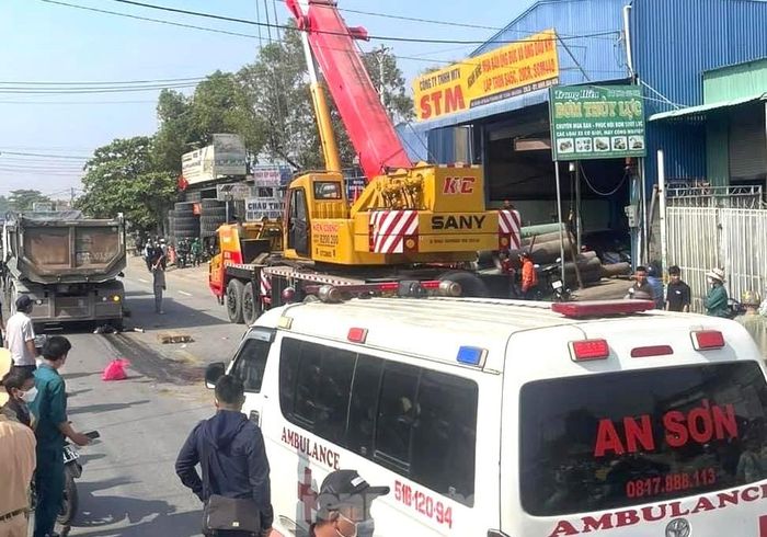 Lực lượng chức năng điều xe nâng để đưa thi thể nạn nhân ra khỏi bánh xe ben