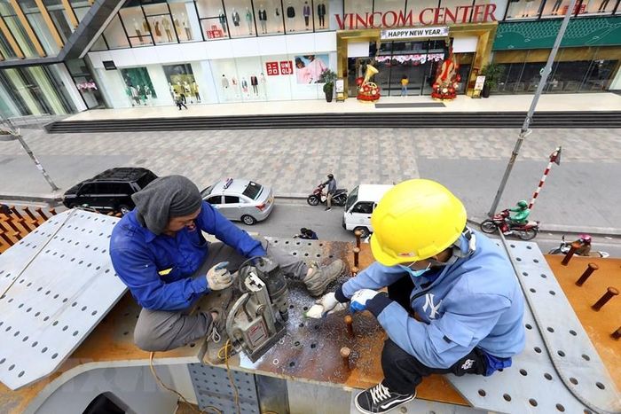 Khoan lỗ để bắt bu lông gia cố dầm cầu. (Ảnh: Huy Hùng/TTXVN)