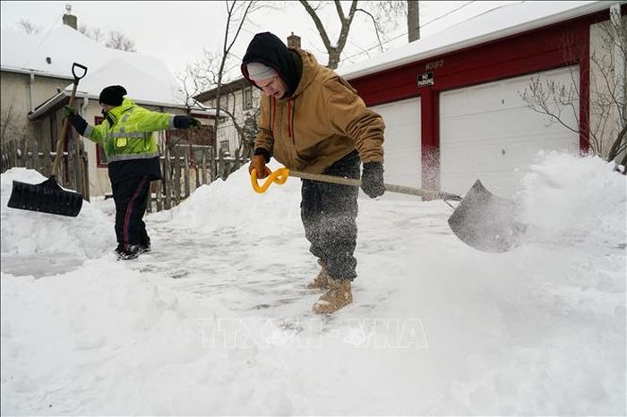 Người dân dọn tuyết tại Minneapolis, bang Minnesota, Mỹ ngày 22/2/2023. Ảnh: AFP/TTXVN