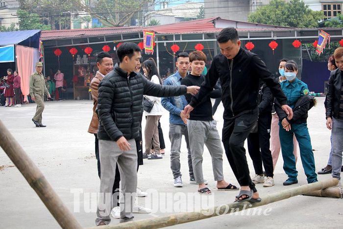 Người dân tham gia trò chơi dân gian đi cầu khỉ.