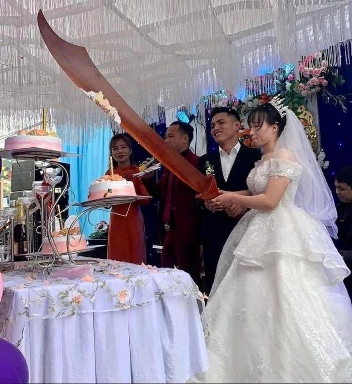 Không ít cặp đôi cô dâu chú rể từng có màn cắt bánh "bá đạo" tương tự. Những hình ảnh độc đáo tại một đám cưới diễn ra tại thị xã Hoàng Mai, tỉnh Nghệ An gây xôn xao khi dùng hẳn một cây "đồ long đao" siêu to khổng lồ để cắt bánh cưới.