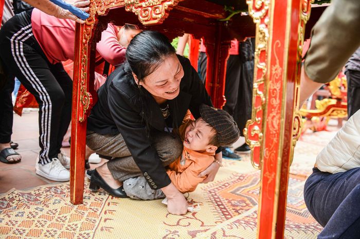  Nhiều người dân, du khách tranh thủ chui qua các kiệu để cầu may. 