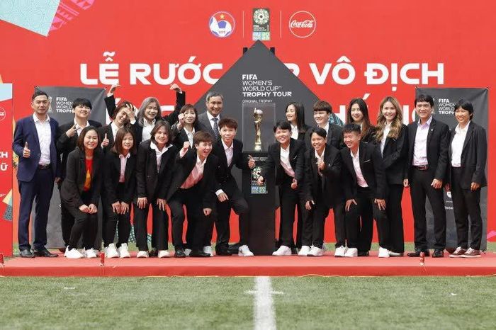 Đại diện Ban huấn luyện, các thế hệ cầu thủ bóng đá nữ Việt Nam bên Cúp vàng World Cup bóng đá nữ FIFA.Ảnh: VFF