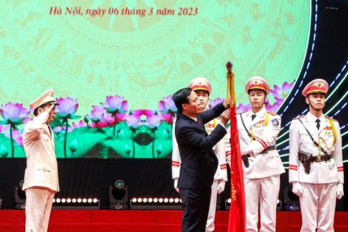 Chủ tịch nước Võ Văn Thưởng gắn Huân chương Bảo vệ Tổ quốc hạng Nhất lên Cờ truyền thống của đơn vị Xây dựng lực lượng CAND.