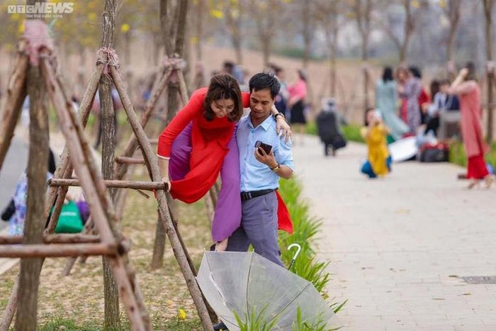 Ngay cả các anh chồng cũng cực kỳ chiều vợ, sẵn sàng đỡ vợ trèo lên cây để có được bức ảnh gần với hoa phong linh nhất. Ảnh: VTC news