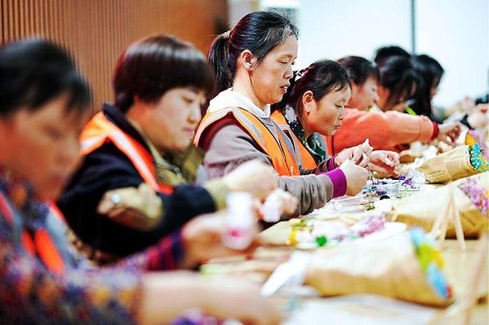 Các nữ thợ xây tại công trường xây dựng thuộc Cục 3 Xây dựng Trung Quốc đang làm "quạt hoa khô". Ảnh: News.cn