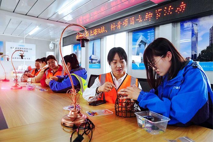 Các nữ công nhân tại công trường xây dựng Dự án Khu công nghiệp thế hệ mới Thượng Hải, làm đèn bàn thủ công. Ảnh: News.cn