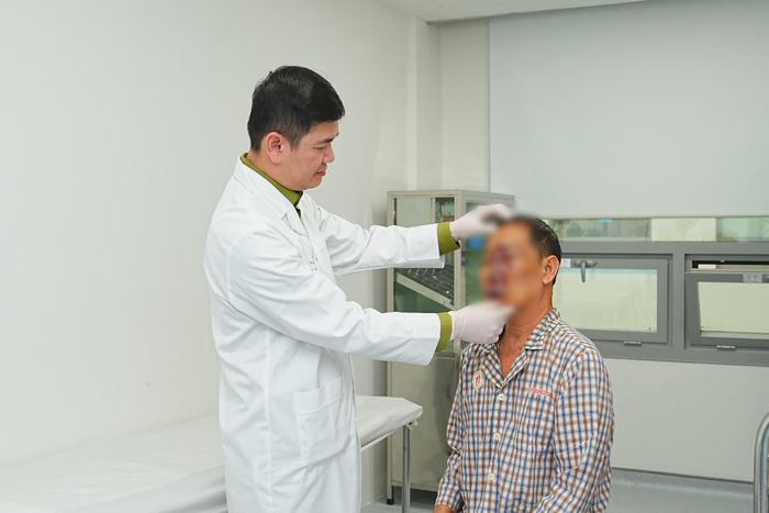 TS.BS Nguyễn Quang Đức khám cho bệnh nhân trước khi ra viện. (Ảnh: An Ngọc)