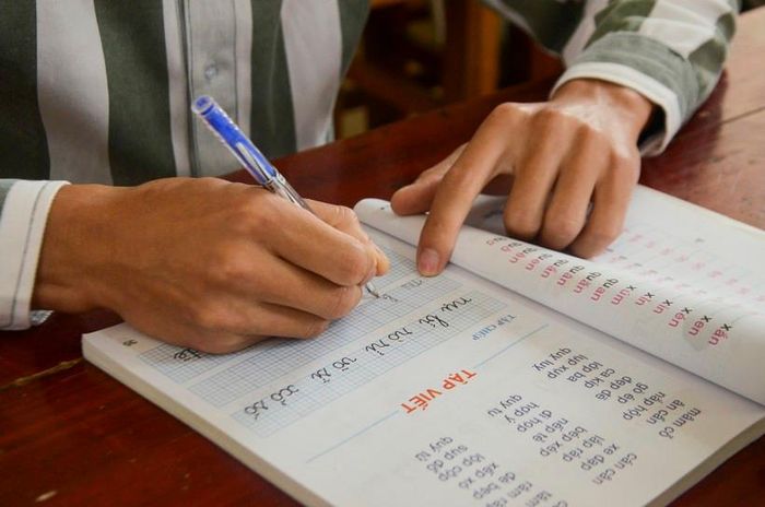 Phạm nhân nắn nót những nét chữ đầu tiên.
