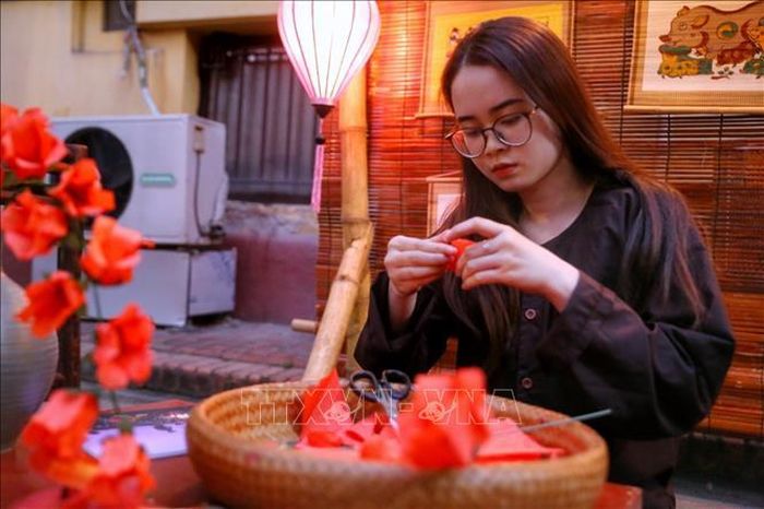 Nghệ nhân gấp hoa gạo bằng giấy. Ảnh: Tuấn Đức/TTXVN