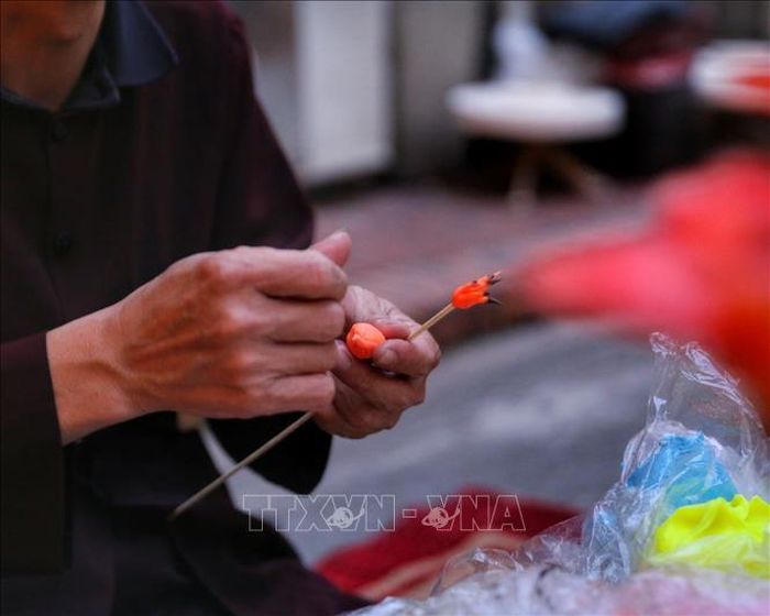 Nghệ nhân làm tò he hình hoa gạo. Ảnh: Tuấn Đức/TTXVN