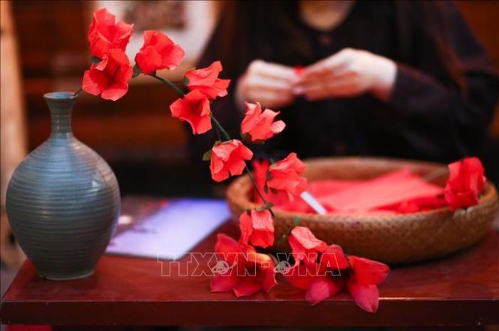Nghệ nhân gấp hoa gạo bằng giấy. Ảnh: Thu Phương/TTXVN phát