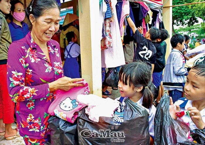 Niềm vui của bà cháu khi lựa được món đồ ưng ý tại gian hàng 0 đồng tổ chức lưu động tại xã Thạnh Phú, huyện Cái Nước.