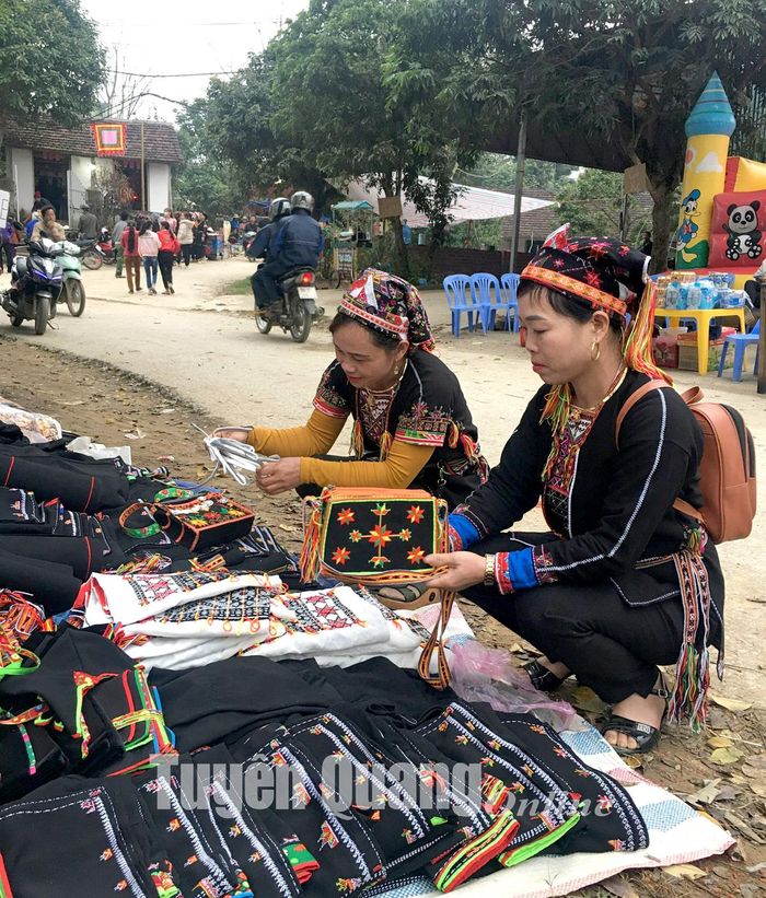 Du khách chọn mua túi thổ cẩm tại chợ Thụt, xã Phù Lưu (Hàm Yên).