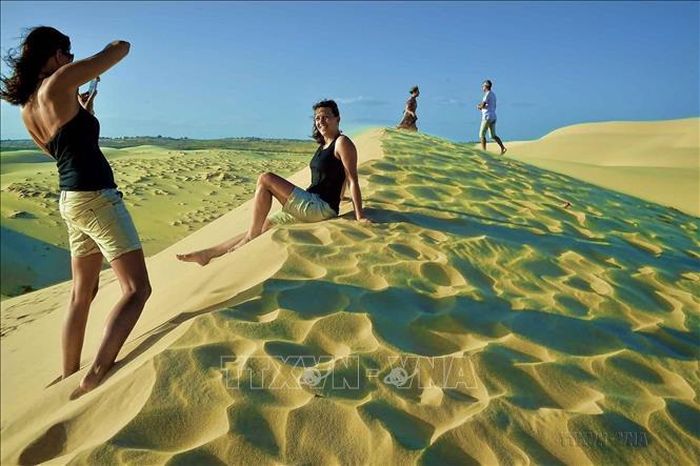 Du khách nước ngoài đắm mình với vẻ đẹp "trời xanh, cát trắng, nắng vàng" ở Bàu Trắng, điểm du lịch hấp dẫn của tỉnh Bình Thuận thuộc địa phận thôn Bình Nhơn, xã Hòa Thắng, huyện Bắc Bình. Ảnh: Thanh Hà/TTXVN