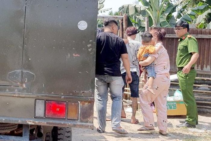  Công an đưa những người liên quan đến địa điểm khám xét. Ảnh: Tiền Phong. 