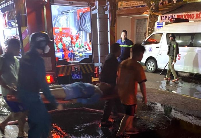 Hai nạn nhân được cảnh sát đưa ra ngoài sơ cứu và chuyển đến bệnh viện điều trị. Ảnh: Đức Anh